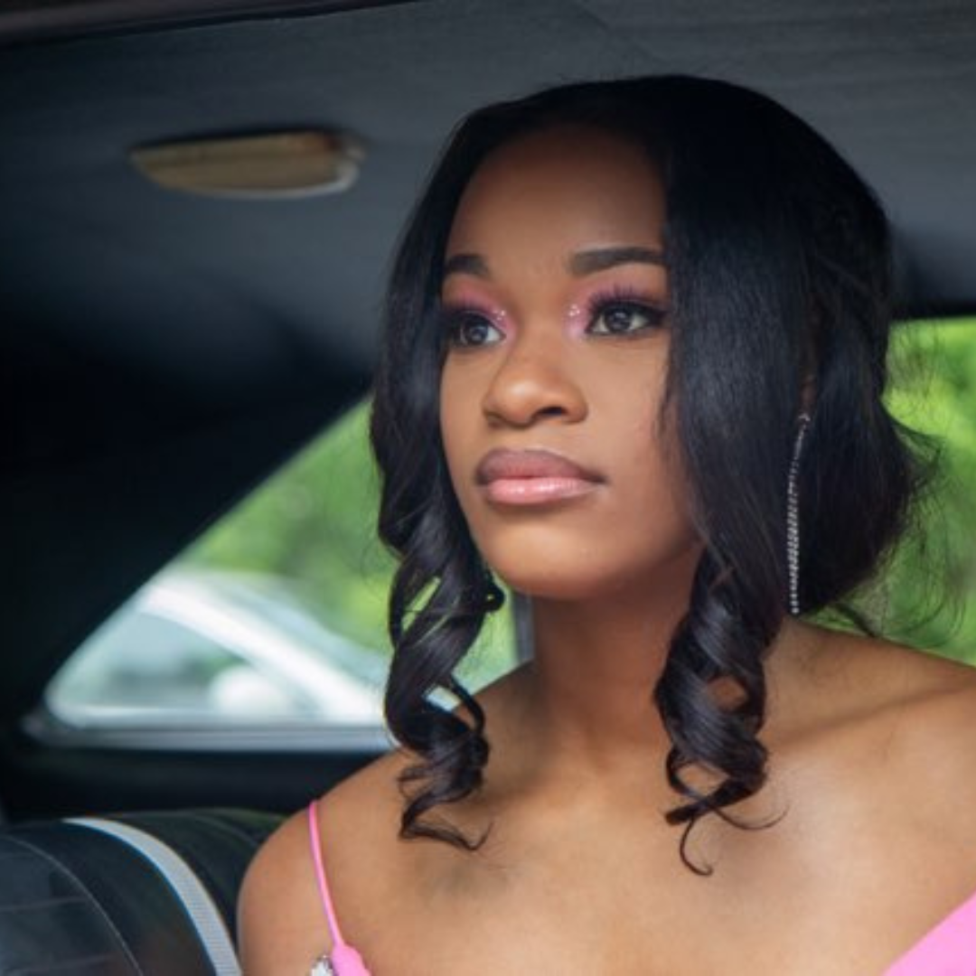 Woman sitting in a car for prom wearing raw loose wave elite glam society bundles